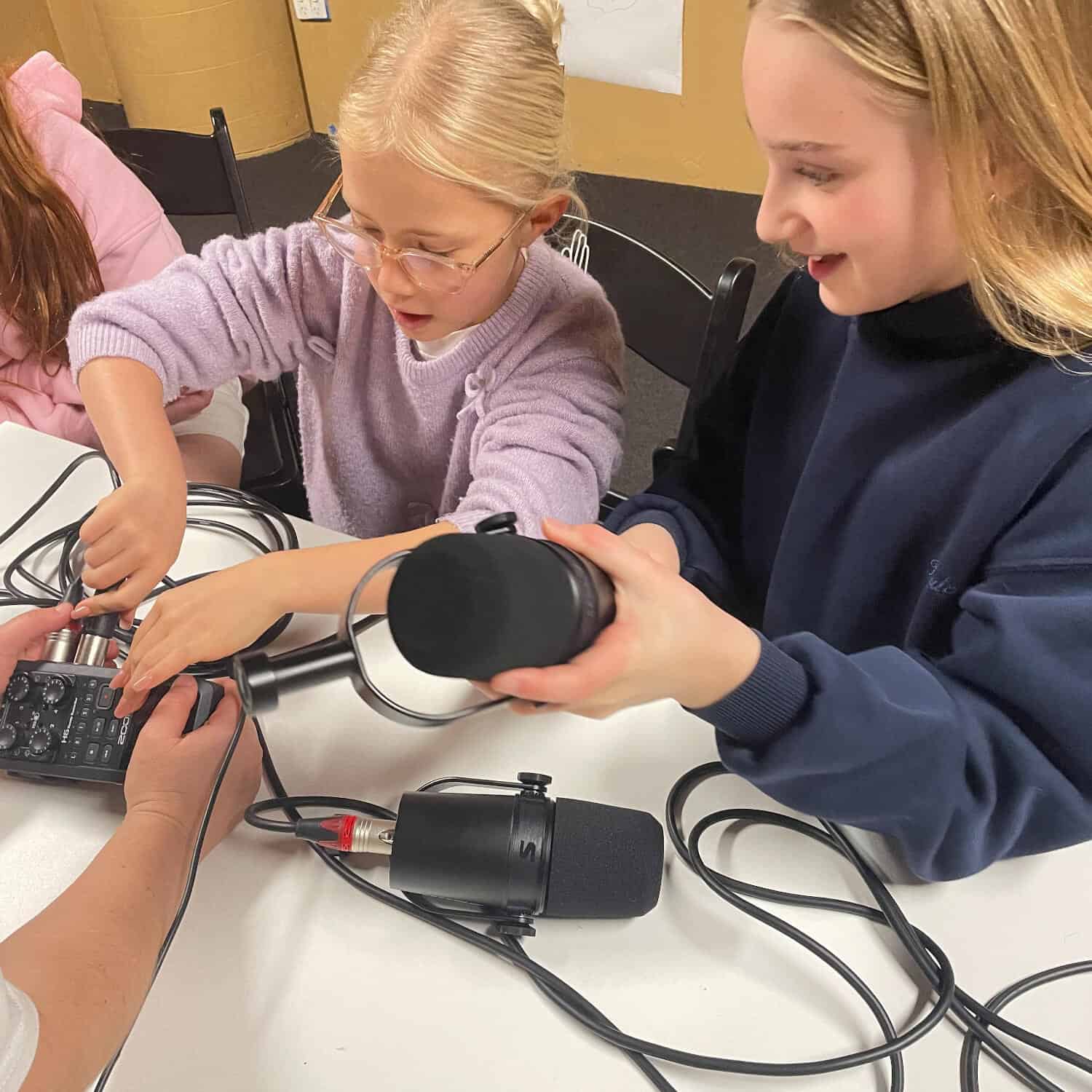 Children exploring audio equipment during a radio workshop at Westsider Radio.